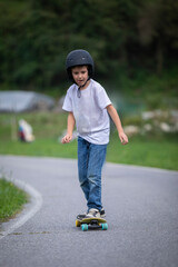 cute boy skating with his skate board on a summer day