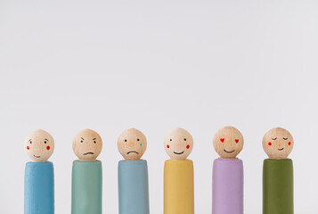 Image of different emotions on wooden peg dolls against white background with copy space.