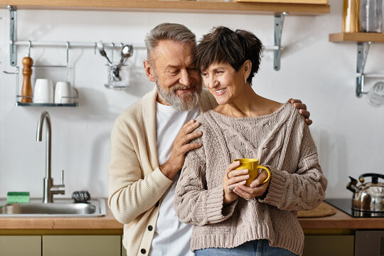 A senior couple shares a sweet moment together in their cozy kitchen.
