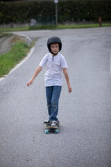 cute boy skating with his skate board on a summer day