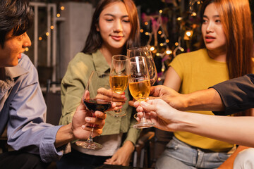 Group of friends clinking wine glasses in celebration at night, Festival celebration, Happy Asian group friends and dinner party in the night, Friendship and celebration new year concept.