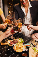Group of friends clinking wine glasses in celebration at night, Festival celebration, Happy Asian...