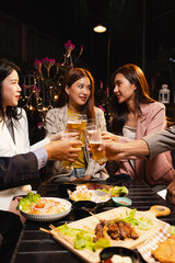 Group of friends clinking beer glasses in celebration at night, Holiday, Festival celebration, Happy Asian group of friends and dinner party in the night, Friendship and celebration new year concept.