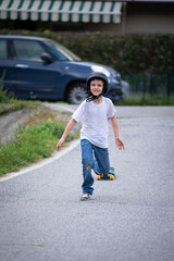 cute boy skating with his skate board on a summer day