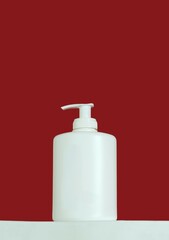 Festive beauty product featuring a minimalist white pump bottle against a vibrant red background. Perfect for holiday skincare, Christmas advertising, or luxury beauty. Winter-themed promotion. Gift.