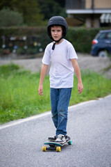 cute boy skating with his skate board on a summer day