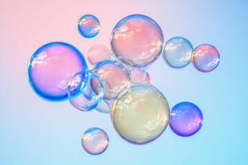 A surreal collection of multicolored bubbles, reflecting a spectrum of hues against a gradient pastel blue and pink background.