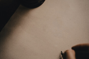 Ink pen writing on a blank piece of white paper. Calligraphic writing with a globe and a candlestick in an old-fashioned style.