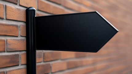 A close-up of a blank black directional sign against a textured brick wall.