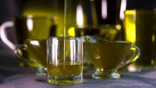 Crane shot of olive oil is being poured into empty beaker on grey background Abstract anti-aging cosmetics ingredients formulating concept