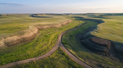 Aerial View of Dirt Road in Expansive Grassland Landscape at Sunset