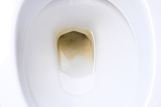 Dirty unhygienic toilet bowl with limescale stain at public restroom close up.