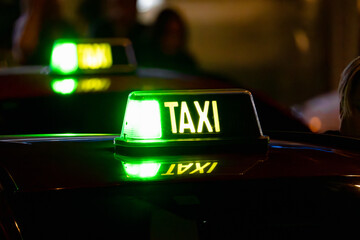 Yellow Green illuminated taxi sign on the roof of the cabin. Showing free taxi seat