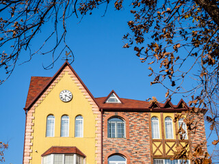 facade of urban house with wall clock in autumn