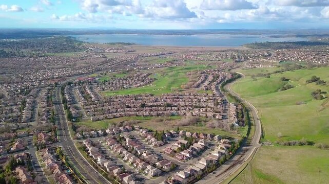 Aerial flyover of Folsom, California with Folsom Lake in the background.