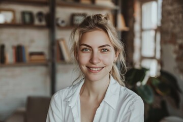Obraz premium Portrait of a blissful woman in her 30s wearing a classic white shirt on stylized simple home office background