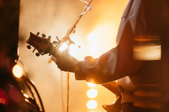 Guitarist at a concert, musician playing instrument - Powered by Adobe
