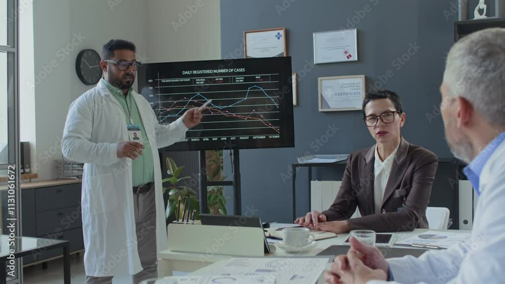 Poster multiracial doctor in white coat presenting data on large screen with graphs and statistics to colle