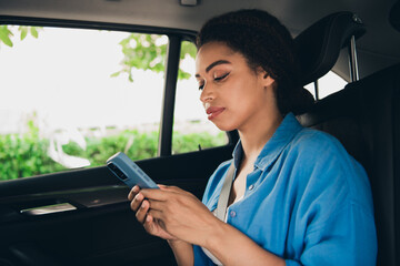 Young woman enjoying a mobile moment in the car on a sunny day