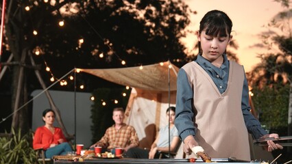 Family gather celebrate holiday, Adorable child grill food for family member. Outdoor camping...