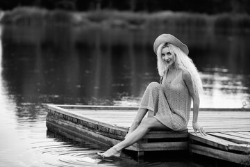 Portrait of a beautiful young long-haired blonde in nature. Black and white photo.
