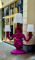 decorative object in the form of a large candelabra of bright pink color with white lampshades,...