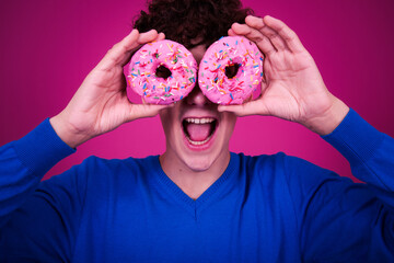 Diet and healthy lifestyle. Funny curly guy eats a donut.