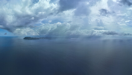 Naklejka premium Rain clouds drift across the seascape north of Sulawesi, Indonesia. This beautiful, tropical area experiences a distinct wet and dry season every year and receives 2.3 inches of rain annually.