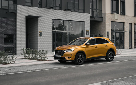 Orange SUV parked on the street in residential district. Three quarter front view of french crossover DS7 Crossback parked in a city near modern building. Kyiv, Ukraine - June 14 2020.