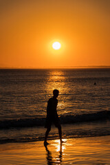 person on the beach at sunset