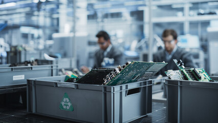 Indian And Caucasian Male Workers Taking Apart Laptops To Recycle For Production Of Digital Devices...