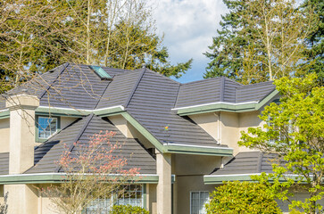 Top of grey luxury house with shingle roof, red and yellow trees and nice windows in Summer in...