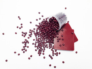 Radish color masterbatch granules spilling from the cup,with color chips as the sample of the...