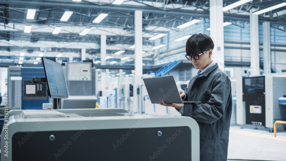 Poster asian male industrial engineer using laptop to control soldering jet printer on electronics factory.
