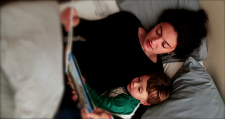 Mother reading bedtime story for toddler child night routine before bed