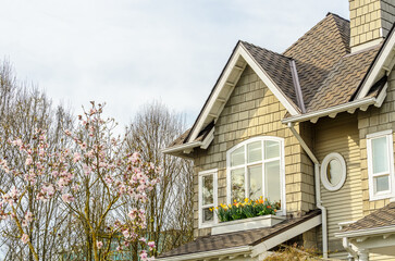 Top of grey luxury house with shingle roof, red and yellow trees and nice windows in Summer in...