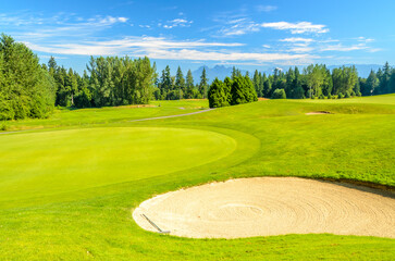 Obraz premium Golf course with gorgeous green and sand bunker.