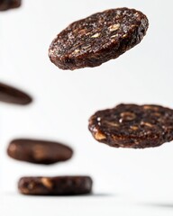 Obraz premium Flying Cookies in Midair Capture with Chocolatey Delight and Oat Texture, Perfect for Food Photography, Cookbook Illustration, or Nutritional Content Imagery