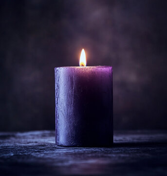 Burning purple candle on dark purple background 