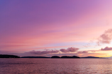 Fototapeta premium Stunning Sunset over Calm Coastal Waters and Distant Islands