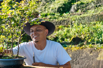 A passionate gardener skillfully cultivating a beautiful bonsai tree in a lush landscape