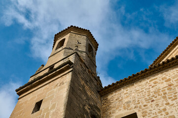 Historic stone tower against a bright blue sky with clouds
