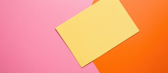 Colorful flat lay of blank yellow paper on pink and orange backgrounds with ample copy space for your creative projects or marketing materials.