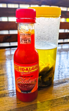 Spicy red chili sauce and pickled habaneros dispenser Costa Rica.