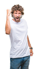 Fototapeta premium Handsome hispanic model man over isolated background angry and mad raising fist frustrated and furious while shouting with anger. Rage and aggressive concept.
