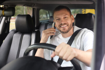 Man talking on phone while driving modern car, view through windshield