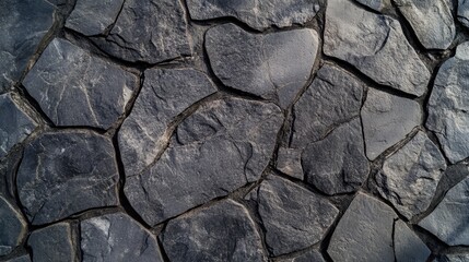 Fototapeta premium Textured stone surface with irregular rock formations showcasing natural gray tones and rugged appearance for design or background use.