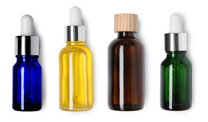 Essential oils in different bottles on white background, top view