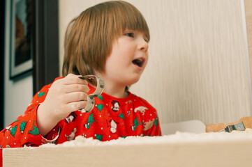 Caucasian boy crafing decorations or opening presents  at home candid shot candind shot winter holiday activities