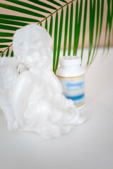 a vitamin jar in a white bottle stands on a table against a background of green leaves. Biologically active additives. omega-6, omega-9, vitamins A, E, D, vitamin D3,